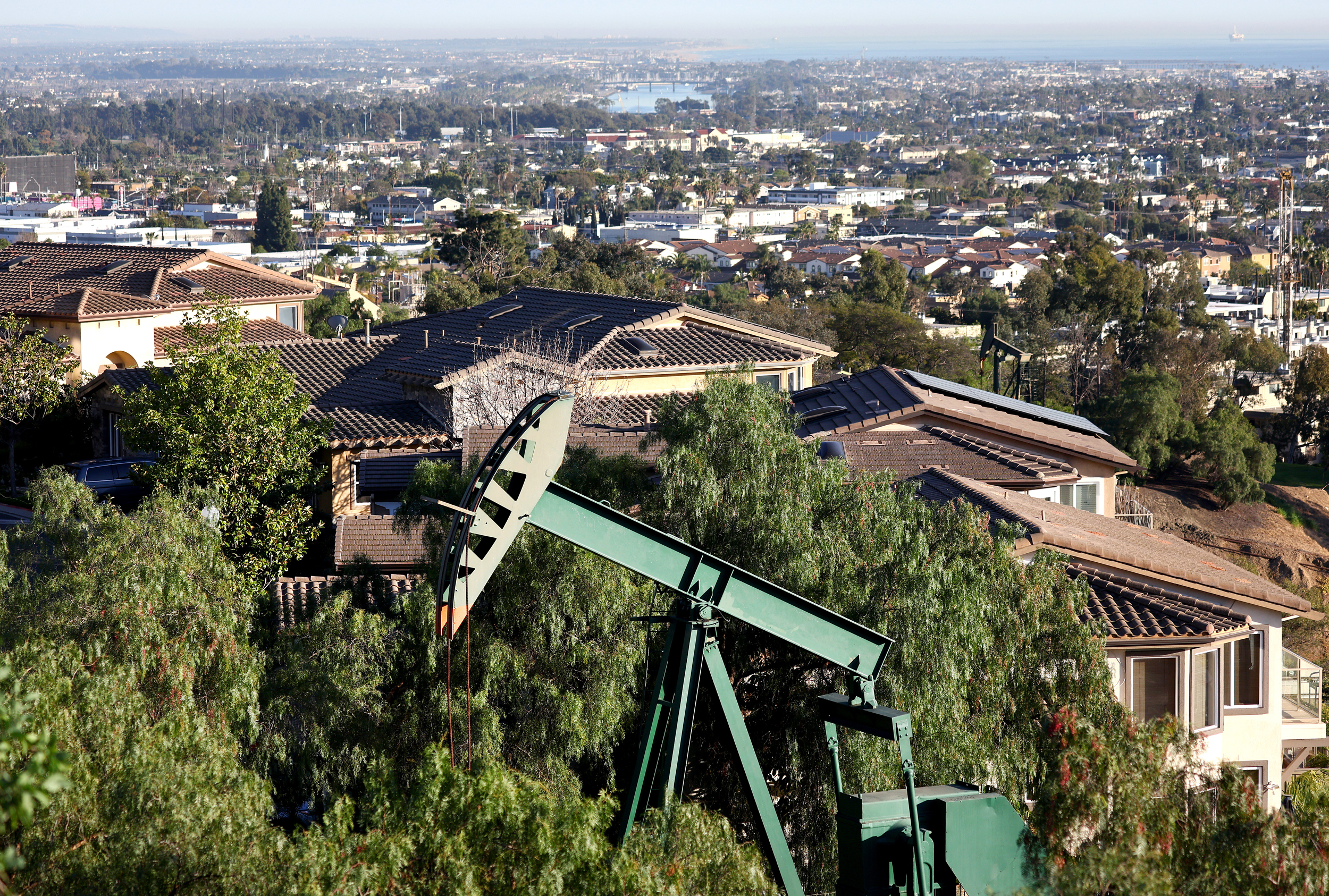 An oil pumpjack sits near homes in Signal Hill, Calif.